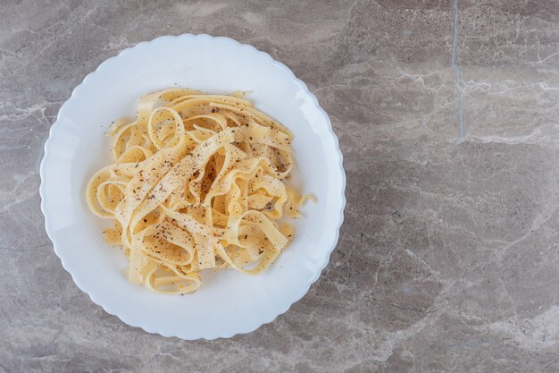 Tagliatelles épicées fraîchement cuites, sur le marbre.