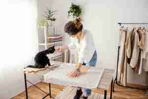 Photo gratuite tailleur féminin travaillant en studio avec chat