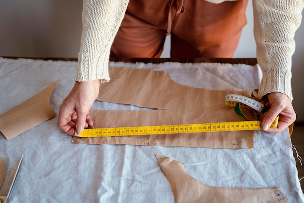 Tailleur femme à l'aide d'une règle pour mesurer le tissu