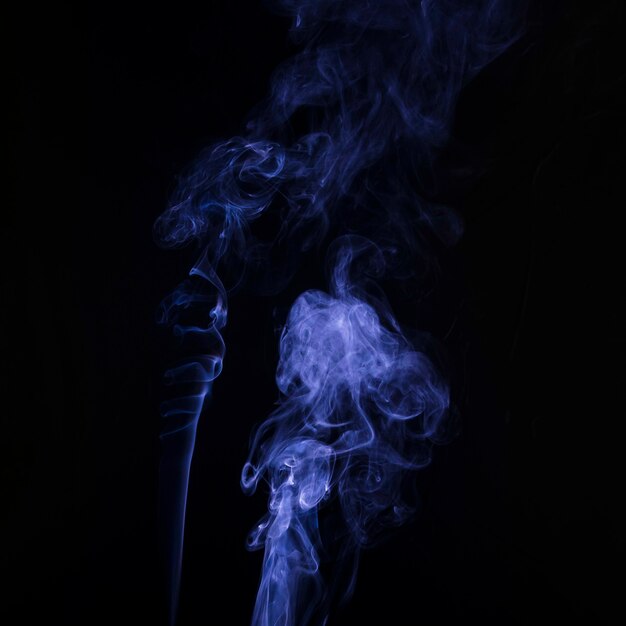 Étaler le flou artistique de la fumée pourpre sur fond noir