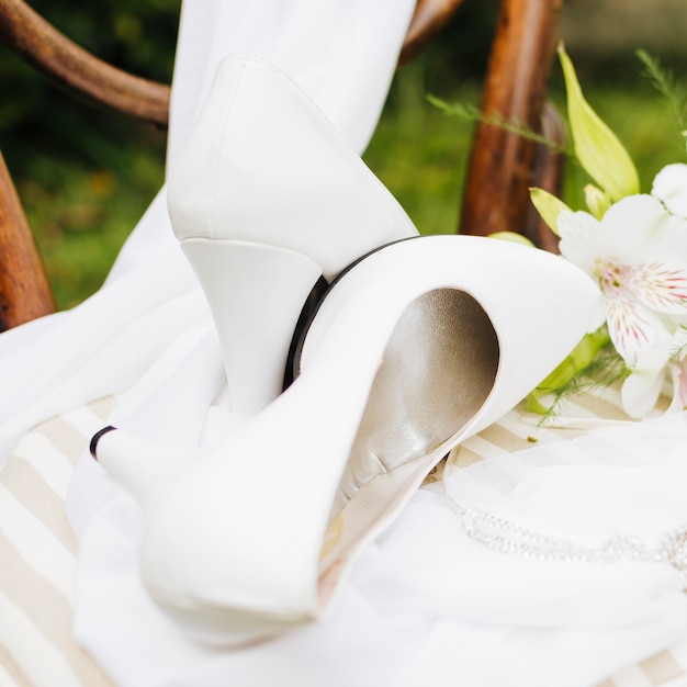 Talons hauts blancs sur l&#39;écharpe sur une table blanche