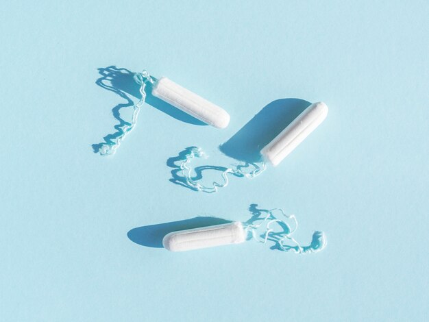 Tampons menstruels avec fil sur fond bleu