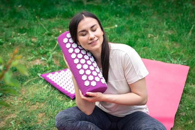 Photo gratuite tapis de massage pour la relaxation et le traitement des mains féminines dans le jardin