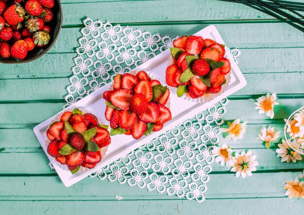 Tartalettes à la fraise rouge en forme de fleur sur la table.