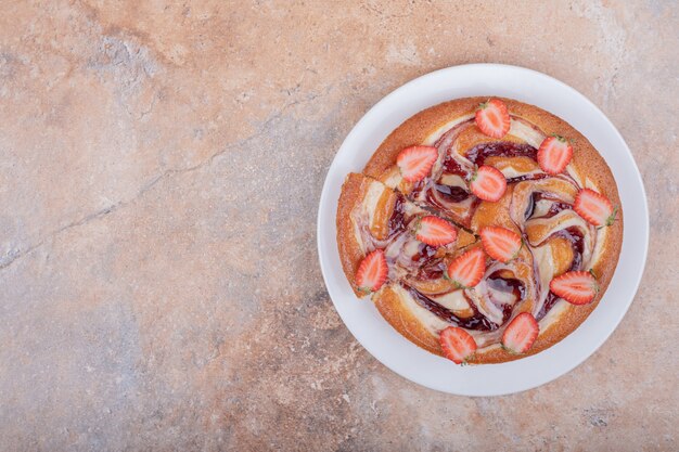 Tarte aux fraises au sirop de chocolat dans une assiette blanche