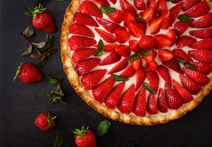 Photo gratuit tarte aux fraises et chantilly décorée de feuilles de menthe. vue de dessus
