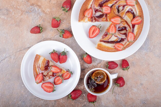 Tarte aux fraises avec une tasse de thé sur une assiette blanche