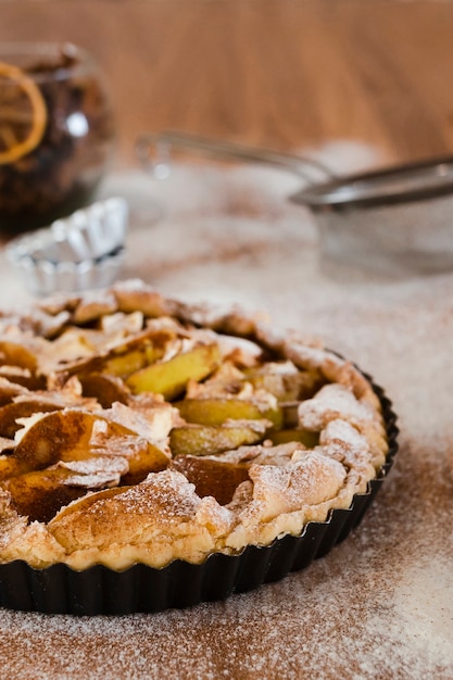 Tarte aux pommes dans un moule avec du sucre en poudre