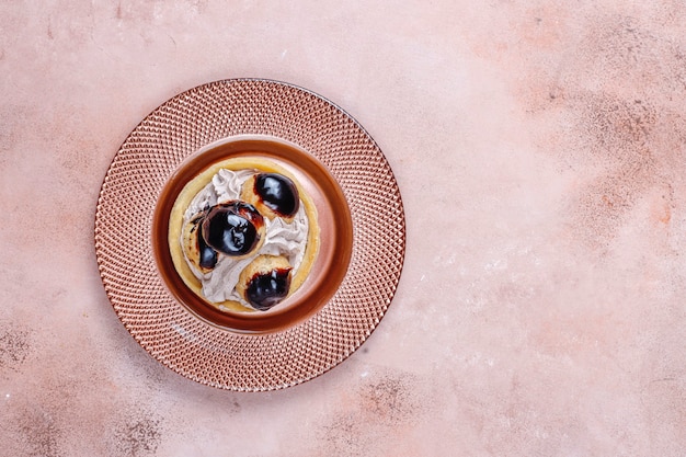 Tarte aux profiteroles sur le dessus avec de la crème fouettée.