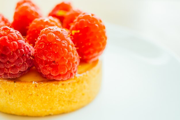 Tarte à la crème sucrée au dessert avec de la framboise sur le dessus