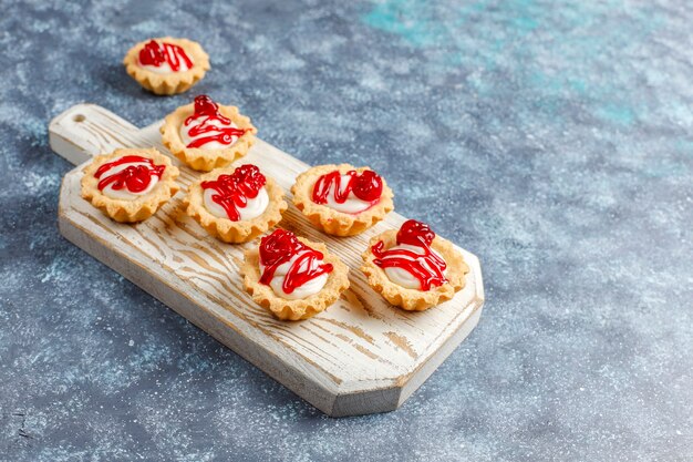 Tartelettes fourrées au chocolat blanc et confiture de petits fruits sur le dessus.