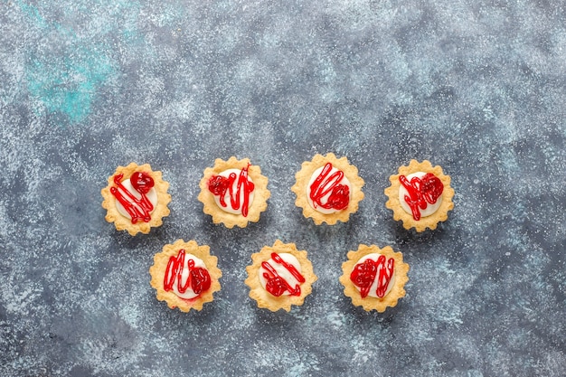 Tartelettes fourrées au chocolat blanc et confiture de petits fruits sur le dessus.