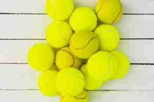 Photo gratuite tas de balles de tennis vertes sur une table en bois