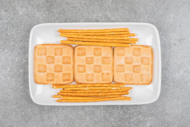 Tas de biscuits et bretzels sur plaque blanche