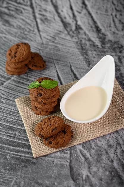 Un tas de biscuits et une cuillère de lait sur un chiffon sur une table en bois