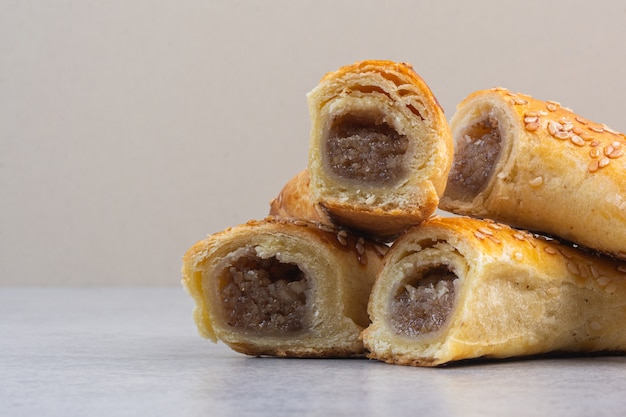 Un tas de biscuits tranchés avec de la confiture, sur le marbre.