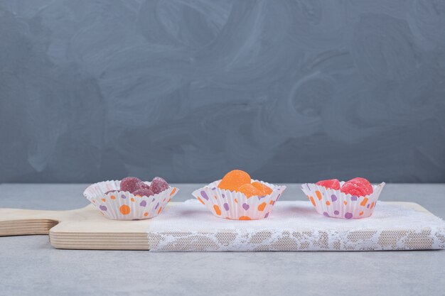 Tas de bonbons à la gelée colorés sur planche de bois. Photo de haute qualité