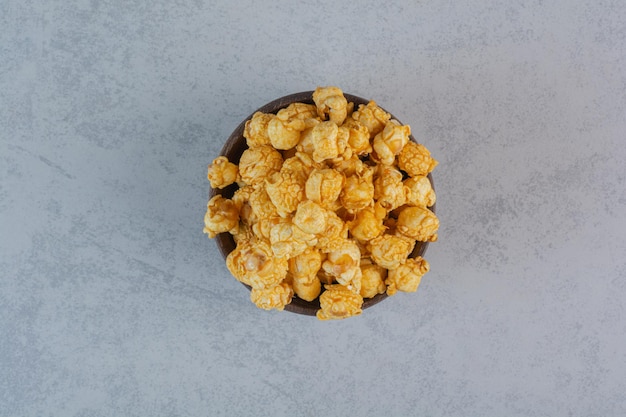 Tas de bonbons pop-corn rempli dans un petit bol sur une surface en marbre