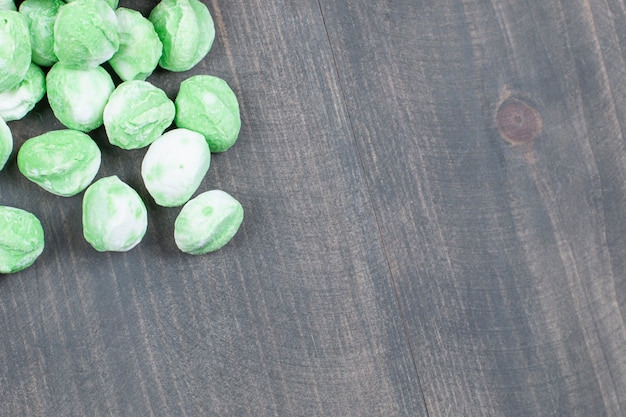 Photo gratuite tas de bonbons verts sur une surface en bois