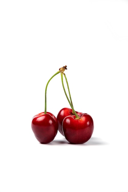 Un tas de cerises rouges sur fond blanc