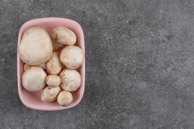 Tas de champignons frais dans un bol rose.