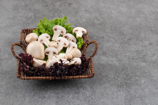 Tas de champignons sur panier avec des verts