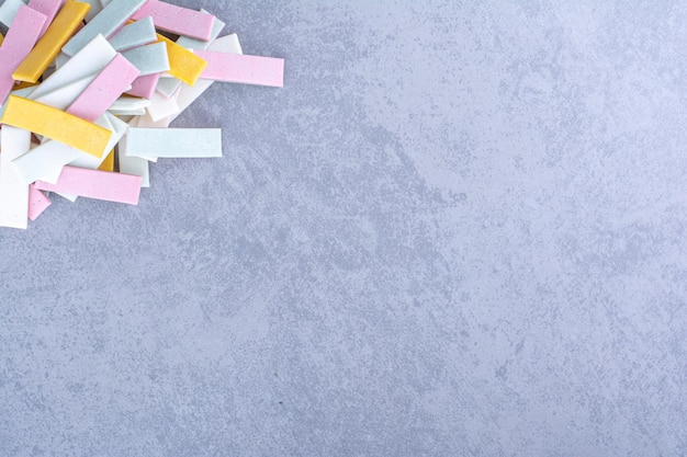 Tas coloré de bâtonnets de chewing-gum regroupés sur une surface en marbre