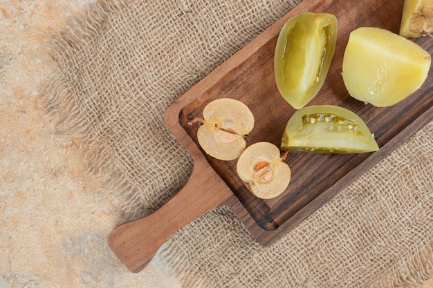 Tas de cornichons mixtes sur planche de bois