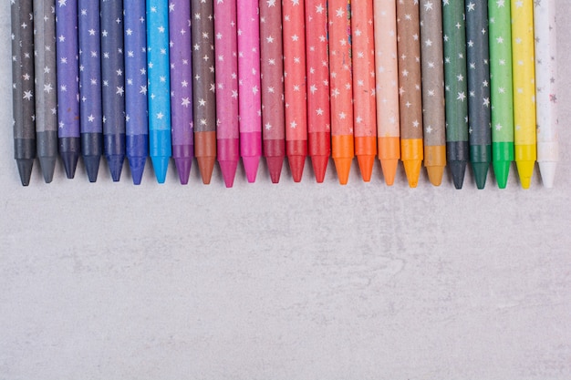 Tas de crayons colorés sur une surface blanche