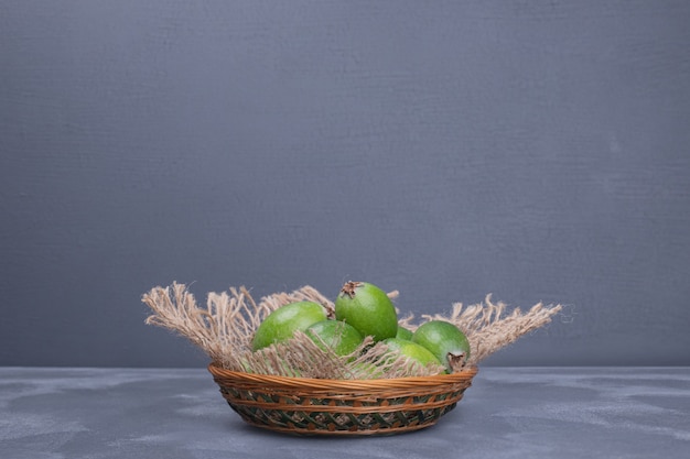 Photo gratuite tas de feijoas dans un bol sur fond bleu.