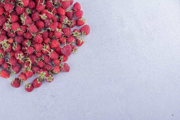 Tas de framboises éparpillés sur fond de marbre. photo de haute qualité