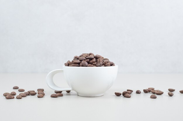 Tas de grains de café dans une tasse blanche