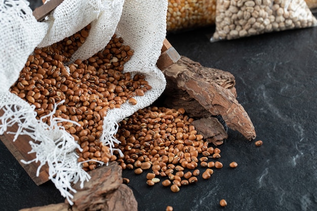 Photo gratuite tas de haricots rouges sur fond noir avec de la toile de jute