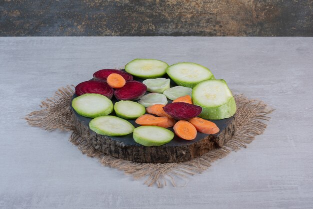 Tas de légumes crus tranchés sur pièce en bois. Photo de haute qualité