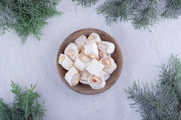 Tas de loukoums et de branches de pin sur fond blanc.