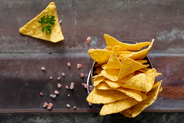 Tas de nachos dans un bocal près de persil