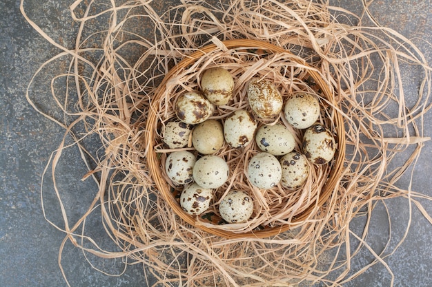 Photo gratuite tas d'oeufs de caille dans un nid en bois.