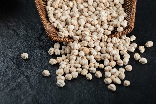 Tas de pois non cuits hors du panier en bois