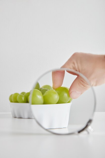 Tas de raisins muscat vert sans pépins de superaliments organiques antioxydants dans un bol en céramique concept pour une alimentation saine et la nutrition isolé sur tableau blanc