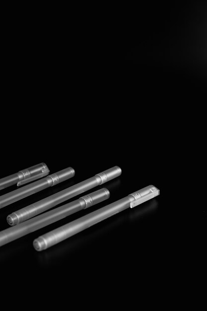 Tas de stylos isolés sur fond noir