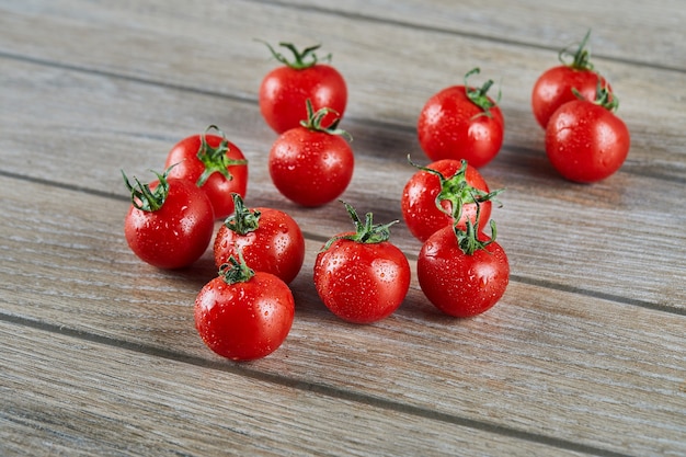 Tas de tomates fraîches juteuses sur table en bois.