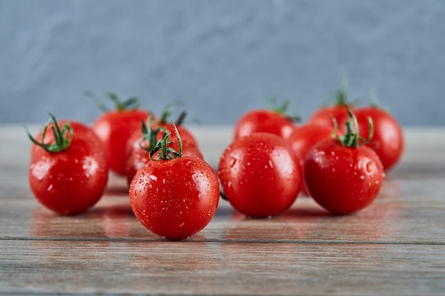 Tas de tomates fraîches juteuses sur table en bois.