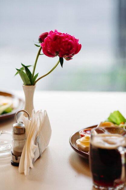 Tasse de bière debout près de l'assiette d'apéritifs Bière brune avec une mousse épaisse et épaisse Debout sur une surface en bois lisse d'une table de restaurant ou de pub Appétissant Froid et frais Pour la compagnie d'amis