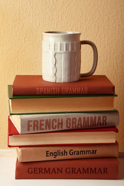 Tasse blanche sur les livres de grammaire