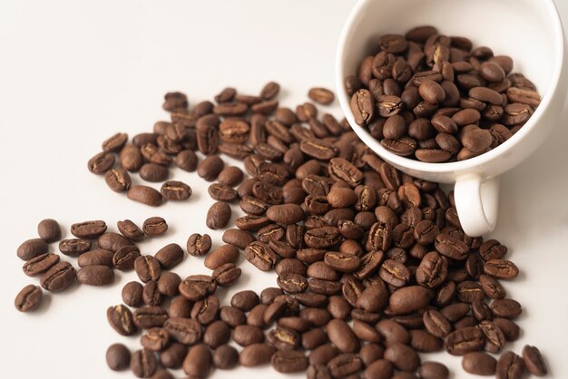 Tasse blanche remplie de grains de café