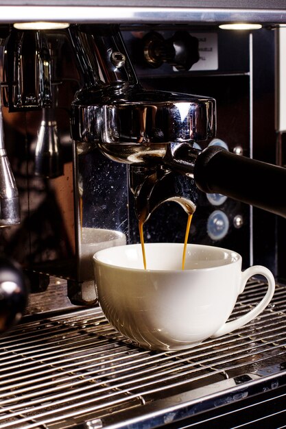 Tasse blanche sous mashine de café