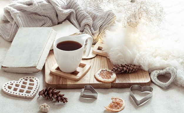 Une tasse de boisson chaude et de jolis articles de décoration. Le concept du confort et de l'esthétique de la maison.