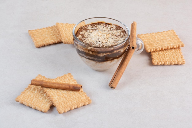 Une tasse de boisson délicieuse avec des craquelins et des bâtons de cannelle