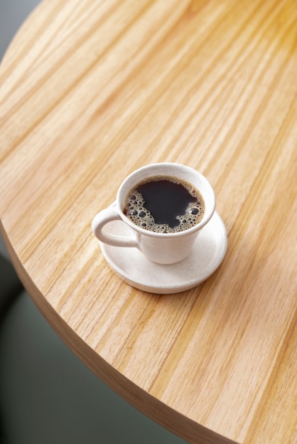 Photo gratuite tasse à café à angle élevé sur une table en bois