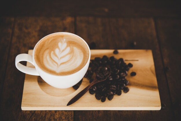 Tasse de café au lait sur la table en bois dans le café-restaurant